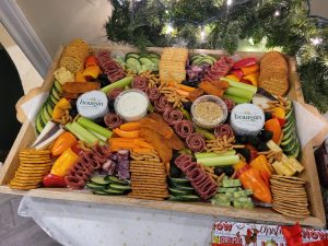 A tray is filled with meats, cheeses, crackers, and vegetables.