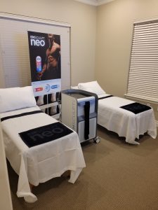 Two spa beds are situated next to each other with a machine in between.